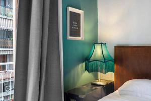 a bedroom with a bed and a lamp next to a window at Mistral Holidays - Minisuite Marina in Marina di Carrara
