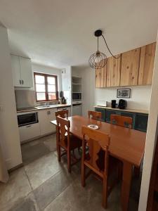 a kitchen with a wooden table and chairs and a dining room at Chalet d'Estive in Cauterets