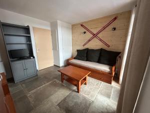 a living room with a couch and a clock on the wall at Chalet d'Estive in Cauterets