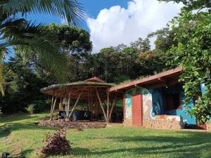 a small house with a red door in the grass at Cabanas ecologicas con vista espectacular y cascada privada - Finca Qawana Ecolodge en San Carlos in Cristalina +22 photos