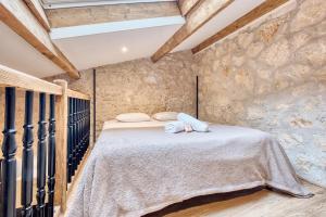 a bedroom with a large bed in a stone wall at La bulle étoilée in Périgueux