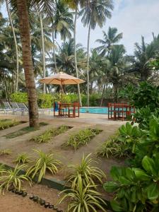 a resort with a pool and a table with an umbrella at Roy Villa Beach Front in Padagala