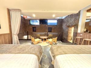 a hotel room with two beds and a table and chairs at 隱山居 海景包棟2-10人 in Jiufen