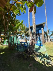 a resort with tables and chairs under palm trees at Camping Gnomo Místico in Olivença