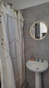 a bathroom with a white shower curtain and a sink at Alojamiento Mililu in Colón