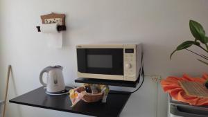 a microwave on a black counter with a coffee pot at Alojamiento Mililu in Colón