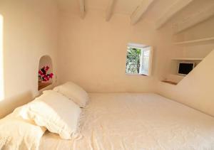 a bedroom with a large white bed with a window at Can Toni Platera in Sant Francesc Xavier