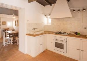 a kitchen with white cabinets and a sink and a table at Can Toni Platera in Sant Francesc Xavier