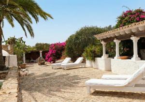 a group of white lounge chairs in a courtyard at Can Toni Platera in Sant Francesc Xavier
