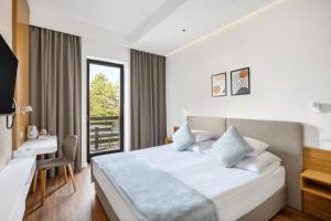 ein Hotelzimmer mit Bett und Schreibtisch in der Unterkunft Cardoner Hotel és Konferenciaközpont in Dobogókő
