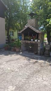 a brick fireplace with potted plants in a yard at Apartman - TAHRIC in Bihać