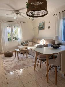 a living room with a couch and a table at La casilla de Miguel con jardín privado y piscinas in Denia