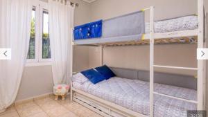a bedroom with two bunk beds and a window at La casilla de Miguel con jardín privado y piscinas in Denia