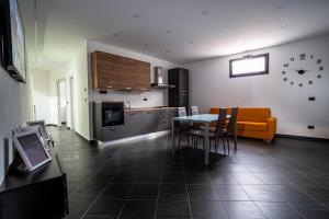a kitchen with a table and chairs and a clock on the wall at B&B Il Trecciolino in Palmi +2 photos