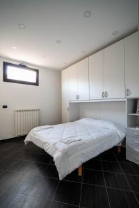 a bedroom with a large bed with white cabinets at B&B Il Trecciolino in Palmi