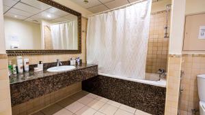 a bathroom with a sink and a tub and a mirror at Prestige holiday home Bed space in Dubai