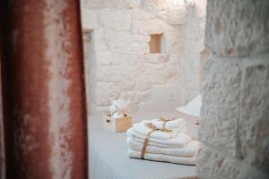 a stack of towels on a bed in a room at Trullo Alisia - TrulloExperience in Putignano +103 photos