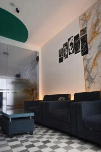 a living room with a black couch and a table at De Azka Style Syariah in Malang