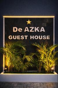 a sign for a gucci guest house at night at De Azka Style Syariah in Malang