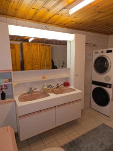 a bathroom with two sinks and a washer and dryer at Duplex Salgesch in Salgesch