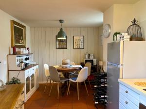 a kitchen with a table and chairs and a refrigerator at Maison Jacquemin in Saint-Pierre