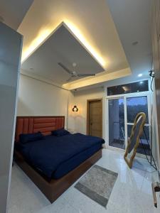 a bedroom with a blue bed and a window at Simbas Den by Abodeandco in Dehradun