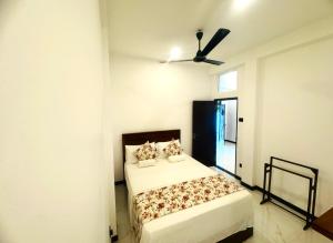a bedroom with a bed and a ceiling fan at Shelo Transit Hotel in Katunayaka