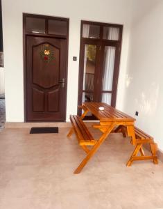 a wooden table and bench in front of a door at Shelo Transit Hotel in Katunayaka +8 photos