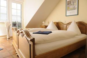 a bedroom with a large bed with white sheets at Gasthof Robens in Dormagen