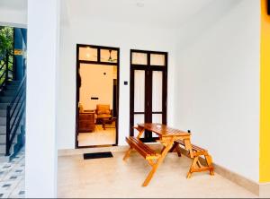 a table and bench in front of a house at Shelo Transit Hotel in Katunayaka