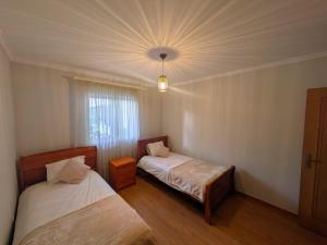 a bedroom with two beds and a ceiling at Pátio do Garajau Apartamento T2 com estacionamento e varanda perto do Cristo Rei in Caniço