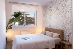 a bedroom with a white bed and a window at Villa Rocamar by Hello Homes Sitges in Sitges +36 photos
