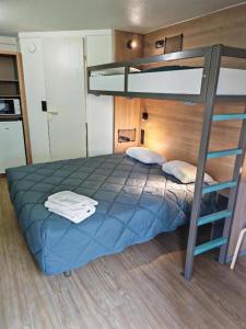 a bedroom with a bunk bed with blue sheets at HOTEL PREMIERE CLASSE Rouen Sud Oissel in Saint-Étienne-du-Rouvray