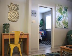 a dining room with a table and a yellow chair at Seaside Flamingo Retreat in Oceano