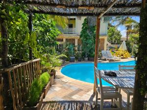 un patio con mesa y piscina en la maison rouge, en Toliara