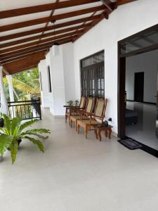 a living room with chairs and a television at Zuulas Palace in Dickwella