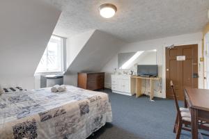 a bedroom with a bed and a table and a television at Le Cavalier du Moulin - M11 in Quebec City