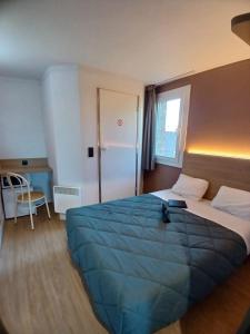 a bedroom with a large bed with a blue blanket at HOTEL PREMIERE CLASSE Rouen Sud Oissel in Saint-Étienne-du-Rouvray +90 photos