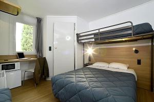 a bedroom with a bed and a desk with a laptop at HOTEL PREMIERE CLASSE Rouen Sud Oissel in Saint-Étienne-du-Rouvray
