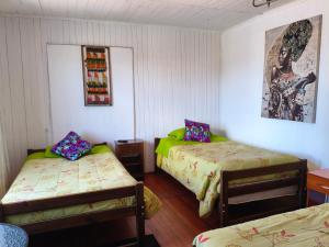 a room with two beds and a picture on the wall at Hospedaje Luna in Valdivia