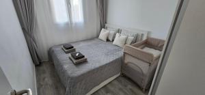 a small bed and a chair in a room at Apartamentos playa Romanilla in Roquetas de Mar