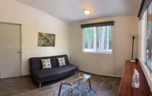 a living room with a blue couch and a window at Casa Kaan Calakmul in Xpujil