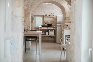 a kitchen with a table and a refrigerator at Trullo Alisia - TrulloExperience in Putignano