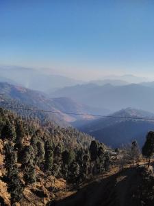 a view of a lake from a hill at Mount aura stay & Dine in Kanatal +55 photos