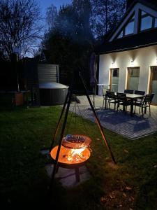a barbecue in the yard of a house at night at Dom na Zadzielu - domek z balią nad Jeziorem Żywieckim in Żywiec