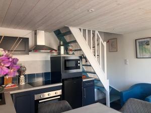 a small kitchen with a staircase in a room at La Ferme de Kérivoas in Audierne