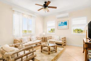 a living room with couches and a ceiling fan at The Babbington Villa in Taylor Bay Beach