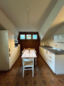 a kitchen with a table in the middle of it at Il Faggio Rosso Apartment in Vernante