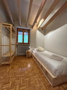 a bedroom with two beds and a wooden floor at Il Faggio Rosso Apartment in Vernante