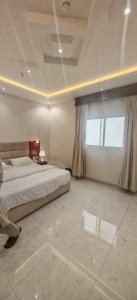 a bedroom with a bed and a large window at شقق درة المصيف in Taif